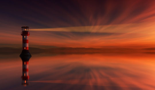 lighthouse at sunset reflected in the water