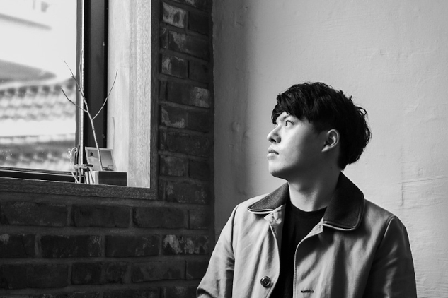 A young man sitting at a table and staring out the window. Image by JUNO KWON from Pixabay.&nbsp;
