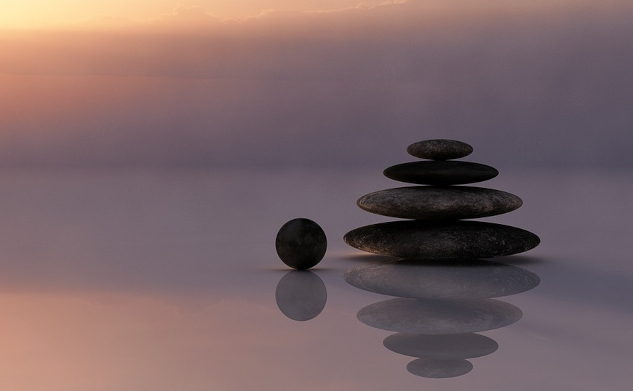 Balanced stones with the top round stone still off to the side. Image by Ralf Kunze from Pixabay.