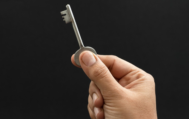 A hand holding a key. Image by Mahesh Patel from Pixabay.