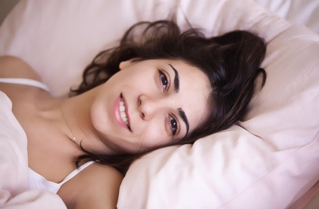 Woman waking up in bed. Image by Claudio Scot from Pixabay.&nbsp;